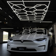 COLMEIA LED ESTUDIO 3 CORES em ambiente moderno com carro elétrico sob iluminação Kers.
